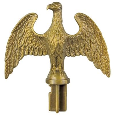 A golden eagle figurine with outstretched wings, mounted on a cylindrical base.